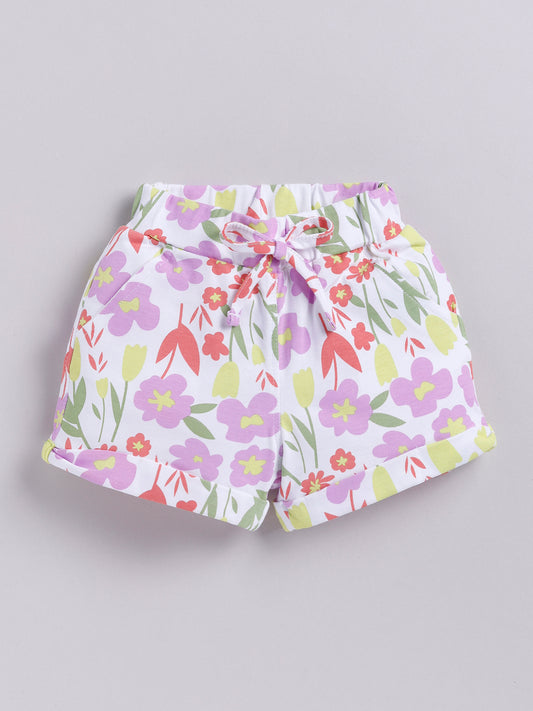 White kids pull-on shorts featuring a sweet floral print of violet flowers and light green leaves, finished with a matching front tie, side pockets, and rolled cuffs