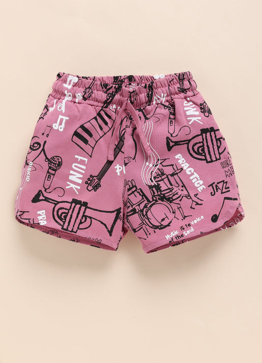 Image file IMG_0367.jpg showing a pair of Biskid brand pink shorts with an elastic waistband, covered in an all-over black-and-white musical graffiti print featuring instruments and music-themed text.