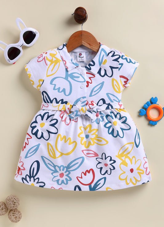Flat lay of an Annie brand girls short-sleeve white frock featuring a collared neckline front buttons a matching waist tie and a vibrant all-over abstract floral print in navy blue light blue yellow and red.