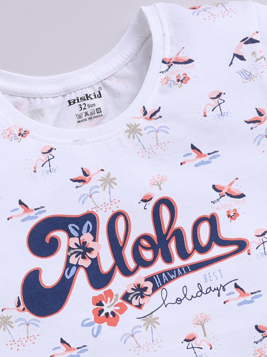 White.jpg showing a flat lay of a white Biskid brand girls short-sleeve t-shirt with an all-over flamingo and palm tree print and "Aloha Hawaii" graphic text on the front.