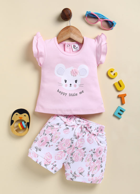 Annie brand girls two-piece clothing set featuring a soft peach flutter-sleeve top with a mouse graphic, 3D flower applique, and the text "happy little me", paired with white shorts featuring a beautiful peach floral print, cuffed hems, and a ruffled elastic waist.