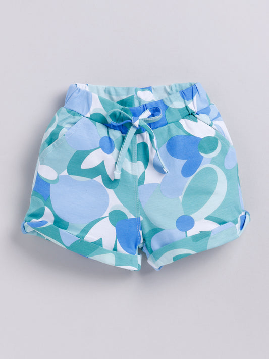 Kids pull-on shorts featuring an abstract retro floral print in shades of blue, teal, and white, finished with an elastic waistband, front tie, and rolled cuffs.