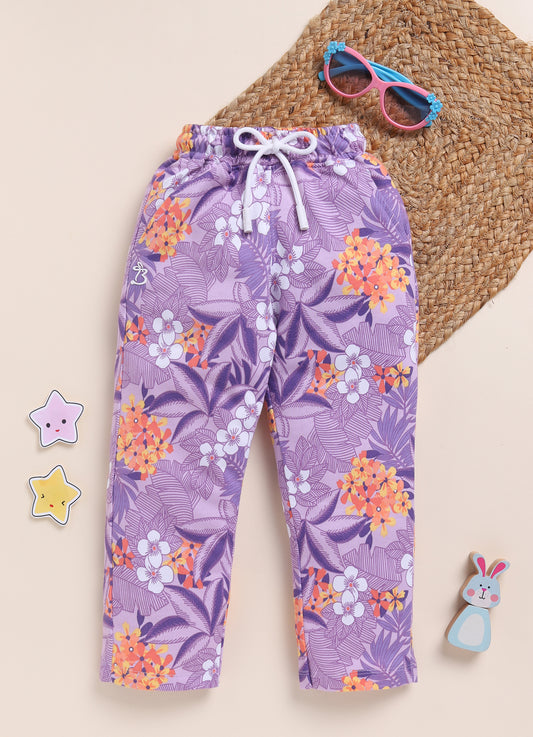 Image file IMG_7054 - Copy.jpg showing a pair of Biskid brand girls purple joggers with an all-over tropical floral print, featuring an elastic waistband with a white drawstring.