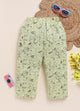 Image file 1512-Lemon.jpg showing a pair of Biskid brand girls' lemon yellow long pants with an all-over botanical print, displayed on a woven mat with pink sunglasses, a toy camera, and yellow decorative flowers nearby.