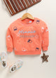 Image file 1751-Orange.jpg showing a Biskid brand girls orange fleece sweatshirt featuring an all-over Minnie Mouse silhouette and star print, displayed on a wooden hanger with children's sneakers and a decorative star accent nearby.
