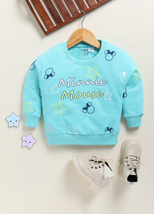 Image file 1751-Skyblue.jpg showing a Biskid brand girls sky blue fleece sweatshirt featuring an all-over Minnie Mouse silhouette and star print, displayed on a wooden hanger with children's boots and star-shaped decorative accents nearby.