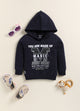 Image file 1756-Blue.jpg showing a flat lay of a navy blue Biskid brand girls hooded sweatshirt featuring the text "YOU ARE MADE OF MAGIC" and associated graphic, displayed with decorative items including children's sunglasses, shoes, and a small toy.