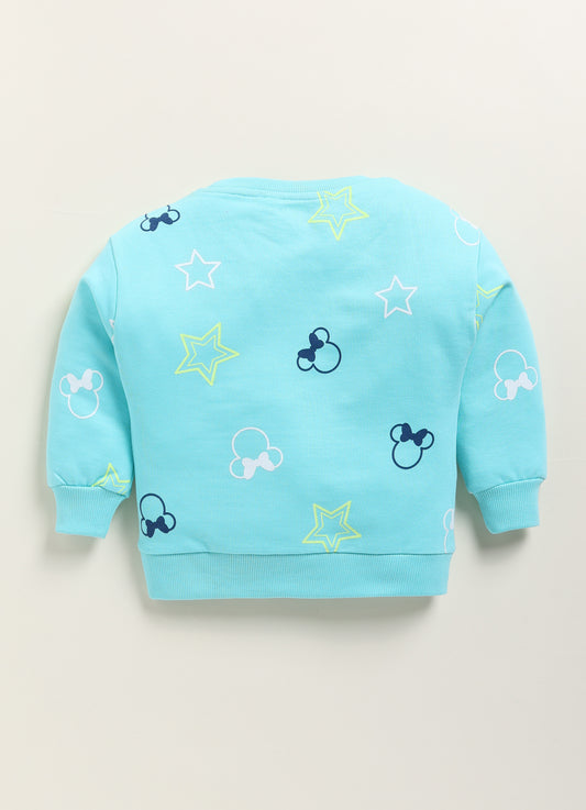 Image file 1751-Skyblue.jpg showing a Biskid brand girls sky blue fleece sweatshirt featuring an all-over Minnie Mouse silhouette and star print, displayed on a wooden hanger with children's boots and star-shaped decorative accents nearby.