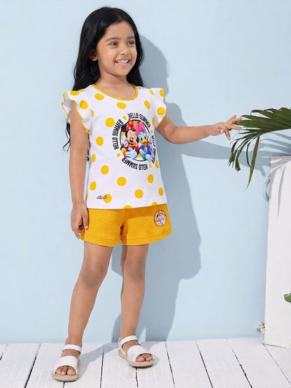 Flat lay of an Annie brand girls two-piece clothing set featuring a white flutter-sleeve top with yellow polka dots and a Minnie Mouse and Daisy Duck Hello Summer graphic paired with bright yellow textured shorts featuring belt loops and a small character patch on the left leg.