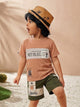 Image file 10407-Rust_2.jpg showing a flat lay of a Unokids brand boys two-piece clothing set featuring a textured rust-colored short-sleeve t-shirt with urban typographic graphics and dark olive green cargo shorts with an elastic drawstring waist and multiple functional pockets.