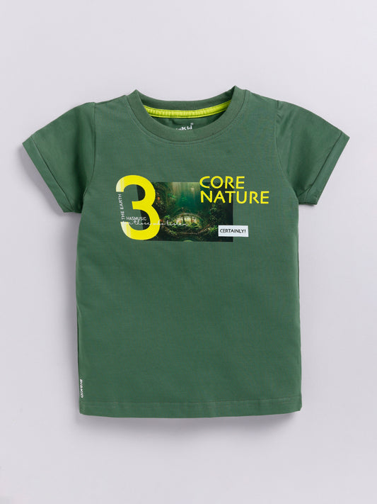 showing a young boy with curly hair modeling a Biskid brand forest green short-sleeve t-shirt. The shirt features a chest graphic containing a photo of a lush green forest, a large yellow number 3, and the text "CORE NATURE" in bright yellow.