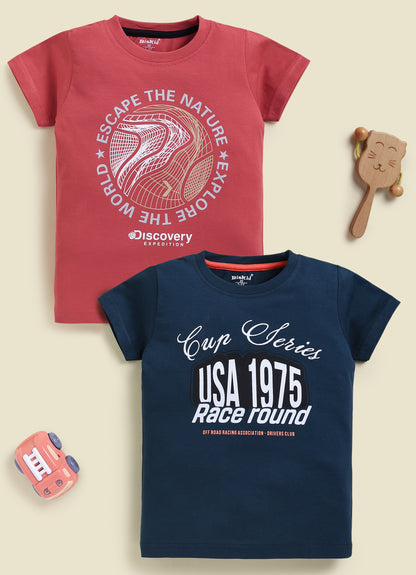 Image file 877-Blu--877-Rust.jpg showing a 2-pack of Biskid boys short-sleeve t-shirts featuring graphic prints, including a rust-red tee with "Discovery Expedition" circular graphics and a navy blue tee with "Cup Series USA 1975" typography.