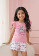 Flat lay of an Annie brand girls two-piece clothing set featuring a peach pink flutter-sleeve top with a too hip to hop Thumper rabbit graphic paired with white textured shorts featuring an all-over Thumper and pink flower print an elastic drawstring waist and pink pocket trim.