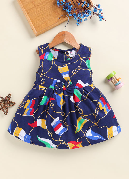 Annie brand girls sleeveless navy blue frock featuring a gently gathered waist with a matching center bow and an all-over nautical print of golden ropes and colorful signal flags.