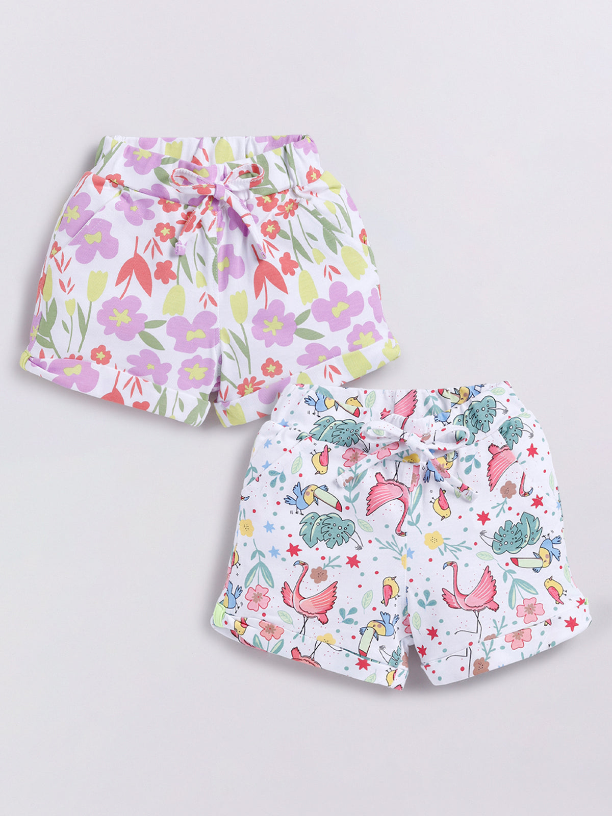 Image file Front combo_2.jpg showing a 2-piece set of Biskid brand girls' casual shorts; one pair features a colorful pastel floral print, and the other features a tropical-themed print with flamingos, toucans, and plants on a white background, both with cuffed hems and drawstring waists.
