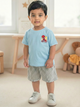 Image file Gemini_Generated_Image_2bgck62bgck62bgc.jpg showing a young boy wearing a sky-blue Biskid brand boys short-sleeve t-shirt with a Spider-Man "WEB-HEAD" graphic on the chest, paired with gray checkered shorts and white sneakers.