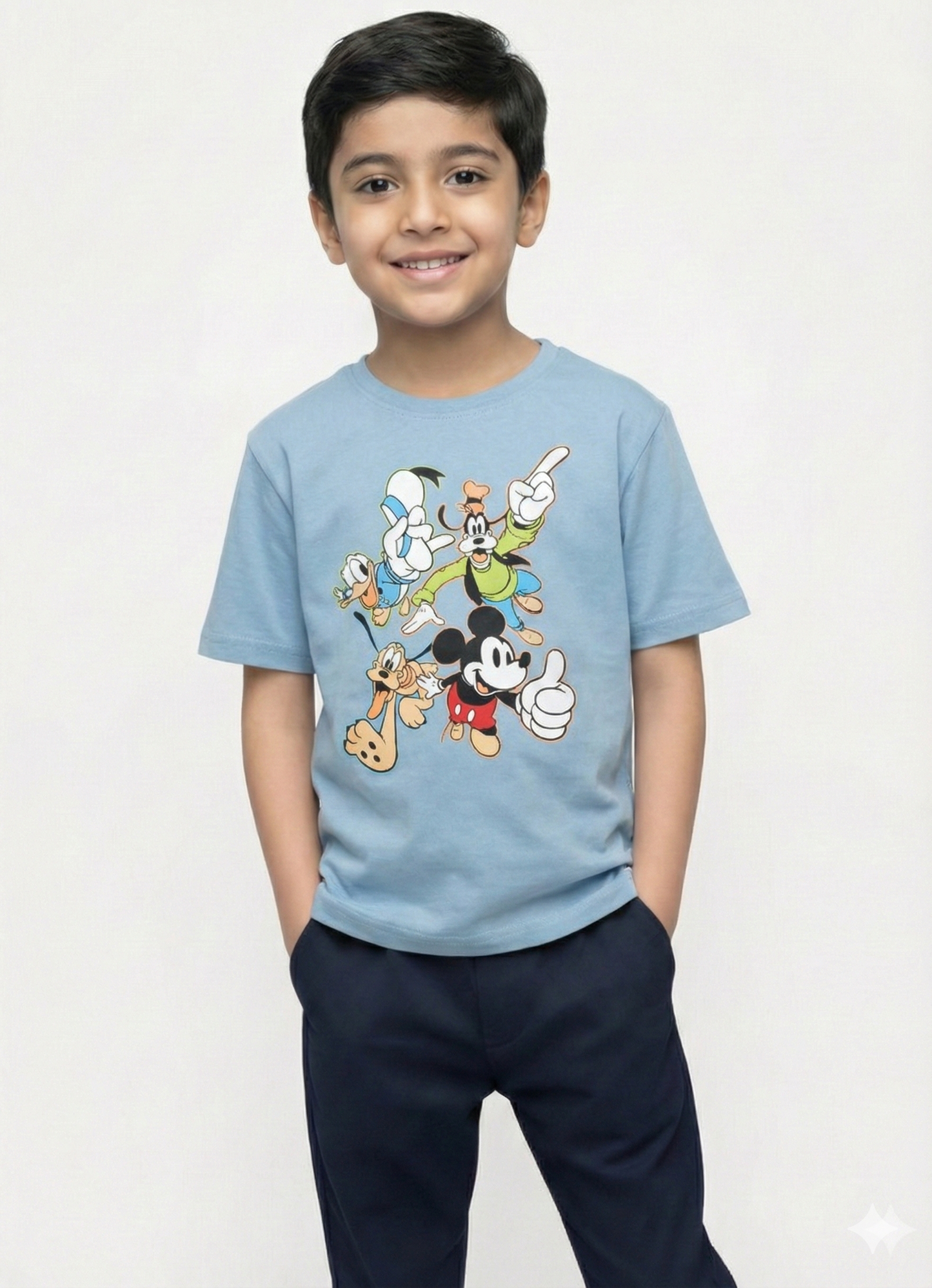 smiling young boy with dark hair modeling a light blue Biskid brand short-sleeve t-shirt. The shirt features a colorful graphic of classic Disney characters including Mickey Mouse, Donald Duck, Goofy, and Pluto in playful poses.