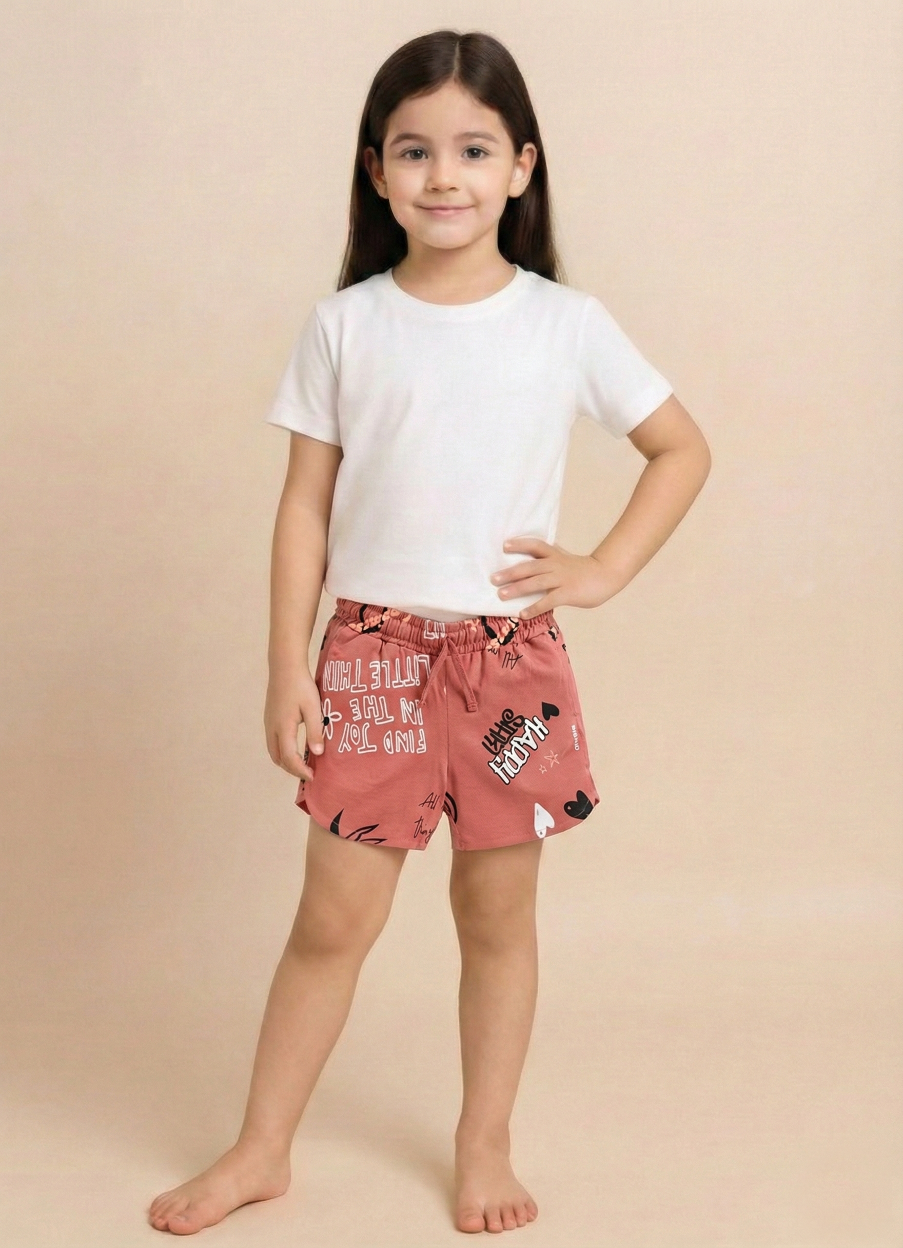 Image file 1409-Peach.jpg showing a pair of Biskid brand peach girls shorts with an elastic drawstring waistband, covered in an all-over beach-themed typography print featuring words like "SWEET" and "COMFORT," with a small "BISKID" brand tag on the side.
