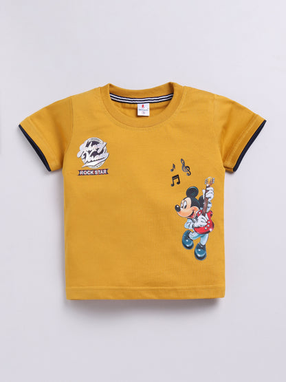 showing a flat lay of a Todos brand boys two-piece clothing set. The outfit features a mustard yellow short-sleeve t-shirt with a graphic of Mickey Mouse playing a guitar and "ROCK STAR" text, paired with dark wash denim shorts featuring an elastic waistband, a mustard yellow drawstring, front pockets, and a "ROCKSTAR" patch on the left leg.