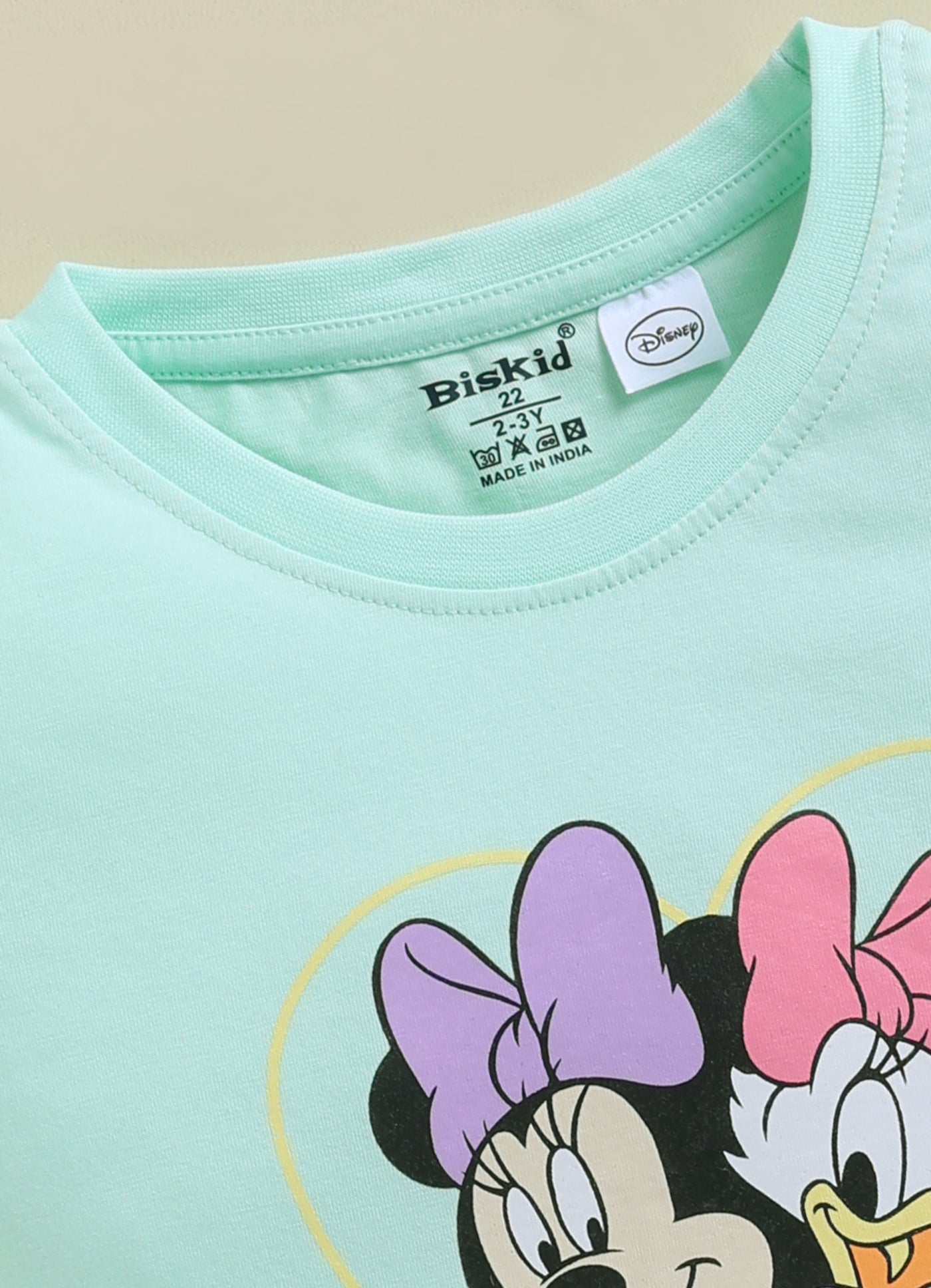 Image file 1819-Pch--1819-Lm.Grn.jpg showing a 2-pack of Biskid girls short-sleeve tops featuring Disney prints, including a peach Minnie Mouse top and a mint green "Best Friends Forever" Minnie and Daisy top.