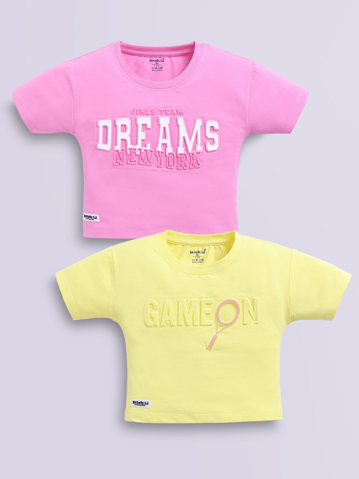 Image file d.pink_lemon.jpg showing a 2-pack of Biskid girls short-sleeve casual crop tops featuring embossed typographic prints, including a dark pink "DREAMS NEW YORK" top and a lemon yellow "GAME ON" top.