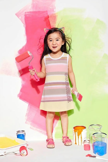 Annie brand girls sleeveless A-line frock. The dress features horizontal stripes in pastel yellow, pink, and taupe, white trim around the neck and armholes, a back snap closure, and the word "SUNSHINE" printed vertically near the bottom hem.