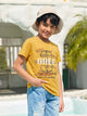 Image file unnamed (30).jpg showing a young boy wearing a Biskid brand mustard yellow crew neck t-shirt with a "GREE" fashion-themed graphic, styled with a beige bucket hat and light-wash distressed denim jeans.