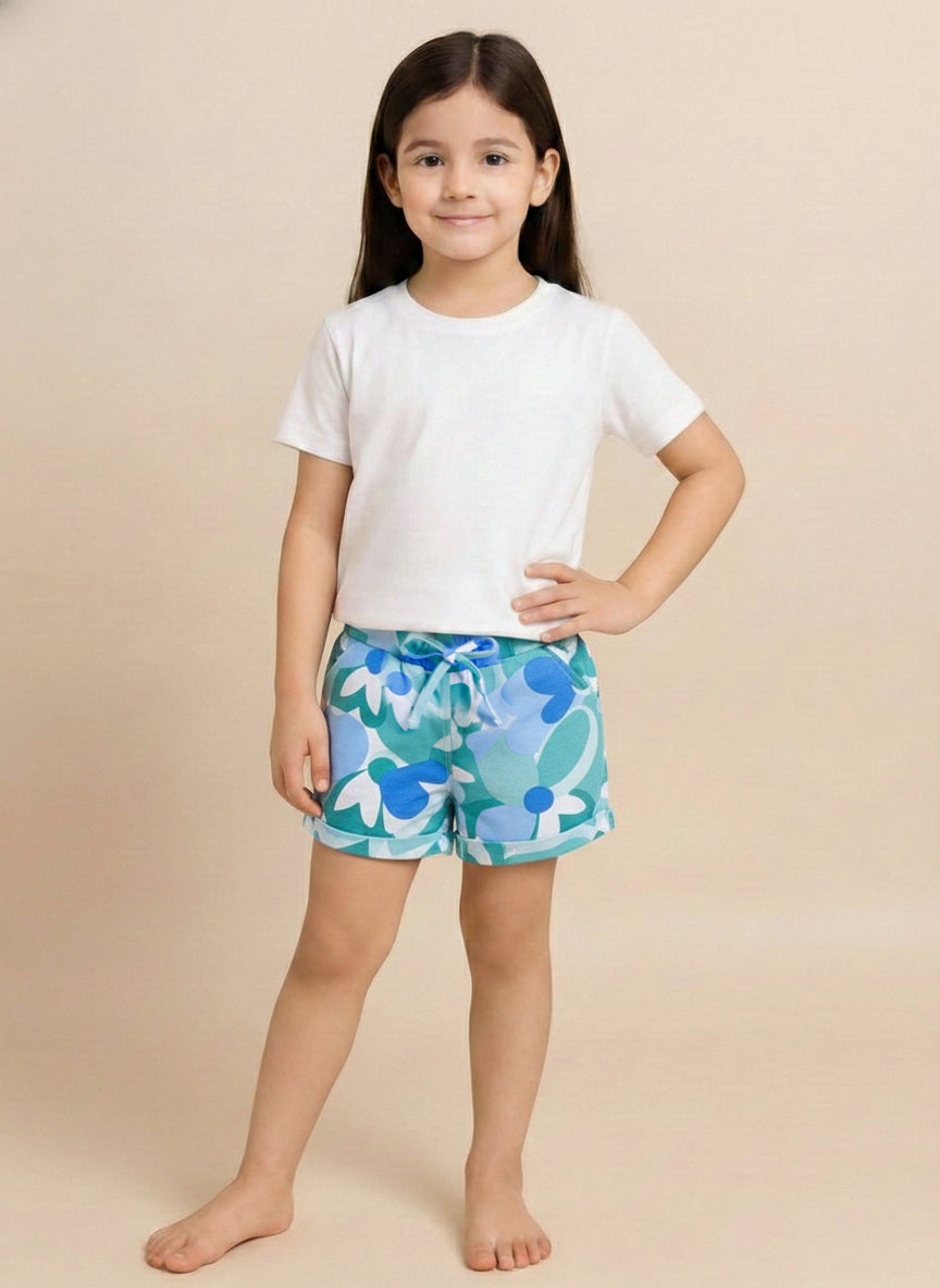 Kids pull-on shorts featuring an abstract retro floral print in shades of blue, teal, and white, finished with an elastic waistband, front tie, and rolled cuffs.
