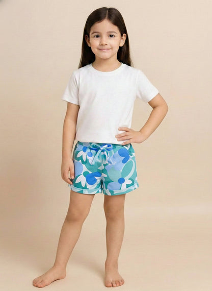 Kids pull-on shorts featuring an abstract retro floral print in shades of blue, teal, and white, finished with an elastic waistband, front tie, and rolled cuffs.