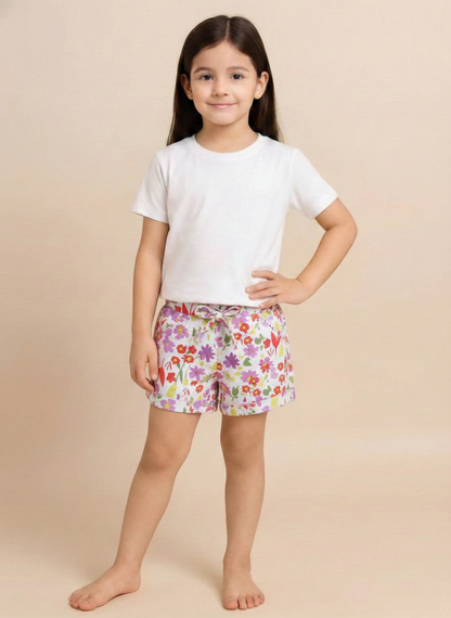 White kids pull-on shorts featuring a sweet floral print of violet flowers and light green leaves, finished with a matching front tie, side pockets, and rolled cuffs